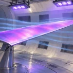 紫外線でピンク紫色に発光する感圧塗料を施した翼模型を、高速カメラで撮影する風洞試験の編集イラスト